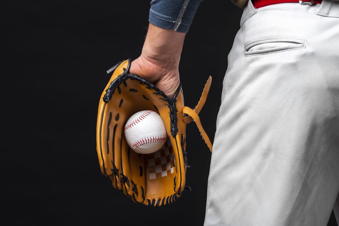 back view man holding glove with baseball